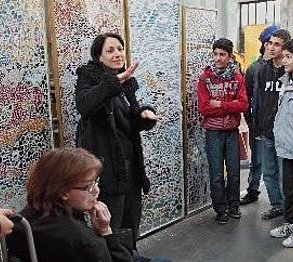 Eine Gehörlosendolmetscherin führt eine Gruppe durch eine Ausstellung.